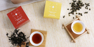 overhead shot of two cups of tea with red and yellow eat with their respective tea boxes next to them in the same colour